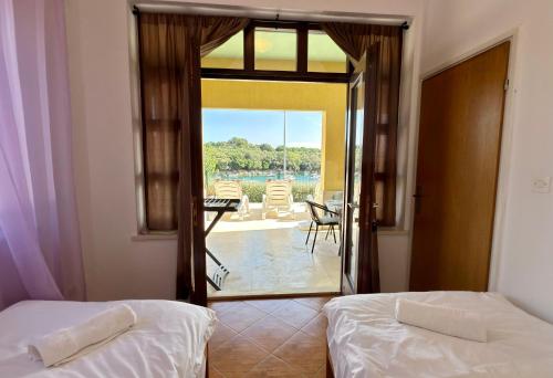 two beds in a room with a view of a patio at VILLAMAR beachfront apartments with FREE private parking in Rabac