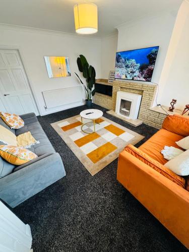 a living room with two couches and a fireplace at Swanky Dudley Retreat in Dudley