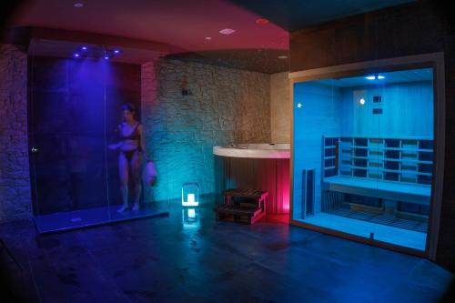 una stanza con una donna in piedi in una stanza con una vasca di Tramonto Ibleo Resort ad Avola