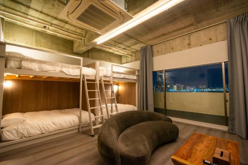 a room with two bunk beds and a table at Visionary Stay HINODE in Tokyo