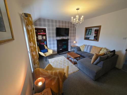 un salon avec un canapé et une cheminée dans l'établissement Cosy Apartment in Fettercairn, à Fettercairn