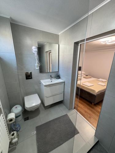 a bathroom with a sink and a toilet and a bed at Casa Luțea in Moieciu de Jos