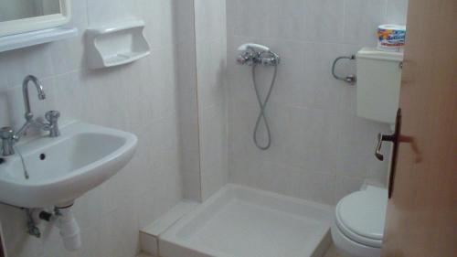 a bathroom with a shower and a sink and a toilet at Creta Vassakis Studios in Kefalos