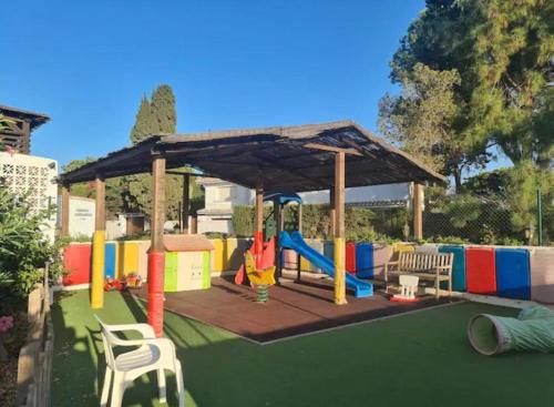 a playground with a canopy and a swing set at Luxury Beach Apartment in Mijas Costa