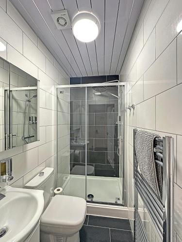 a bathroom with a shower and a toilet and a sink at Granada Apartments at Pleasure Beach in Blackpool