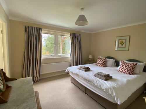 a bedroom with a large bed and a window at Lochs Lodge, Glenlyon, Perthshire in Bridge of Balgie