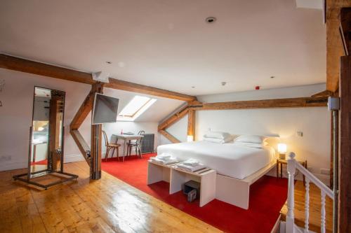 a bedroom with a white bed and a red rug at Kellys Hotel in Dublin