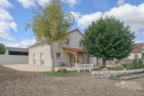 a house with a table and trees in the yard at Résidence Penaud - Appartements design et climatisés à la campagne in Saulcet