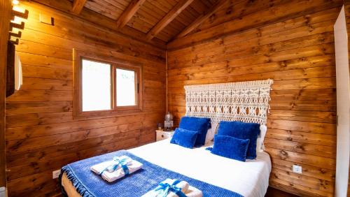 a bedroom with a bed in a log cabin at Casa Alfazema, Quinta Carmo - Alcobaça - Nazaré in Alcobaça