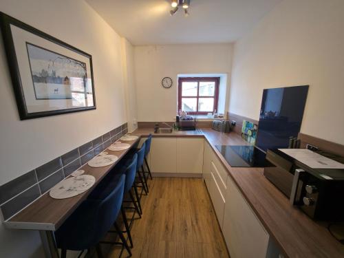une salle à manger avec une grande table et des chaises bleues dans l'établissement Cosy Apartment in Fettercairn, à Fettercairn