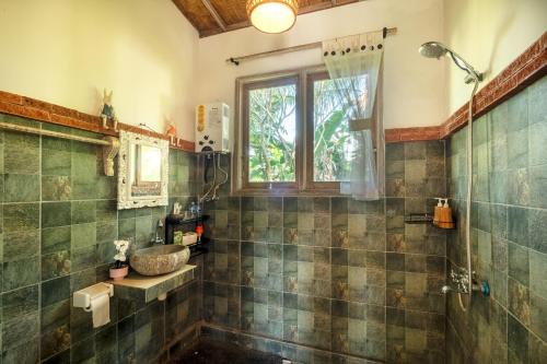 a bathroom with a tub and a sink and a window at Kresna Asih House in Tampaksiring