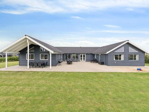 a large blue house with a large patio at Luxury Retreat by Hostrup Beach - By Traum Ferienwohnungen in Spottrup