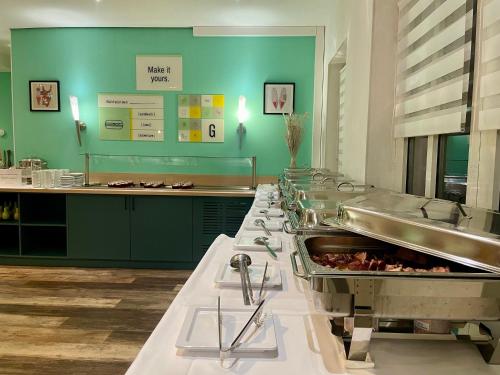 a large kitchen with a row of food at Garner Hotel Cottbus Süd by IHG in Cottbus