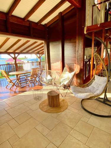 a patio with chairs and a table on a porch at Villa Surf Kreol moderne à 3 min du Souffleur in Port-Louis
