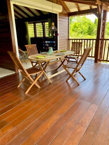 a wooden table and chairs on a deck at Villa Surf Kreol moderne à 3 min du Souffleur in Port-Louis