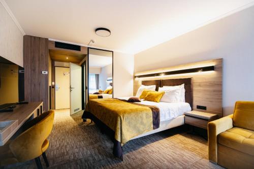 a hotel room with a bed and a desk at Hotel Vivat in Moravske Toplice
