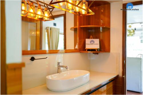 een badkamer met een wastafel en een spiegel bij Mayooram cruises -luxury houseboat in Alleppey