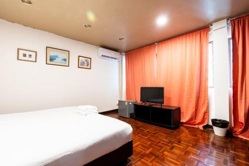 a hotel room with a bed and a television at Stay On Sukhumvit Soi 11 - สเตย์ ออน สุขุมวิท 11 in Bangkok