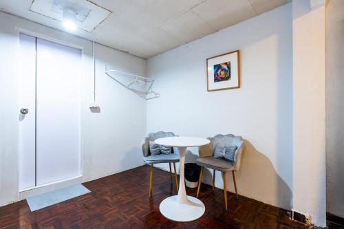 a white room with two chairs and a table in it at Stay On Sukhumvit Soi 11 - สเตย์ ออน สุขุมวิท 11 in Bangkok