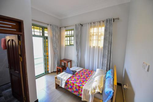 a bedroom with a bed in a room with windows at Guadalupe house in Masaka