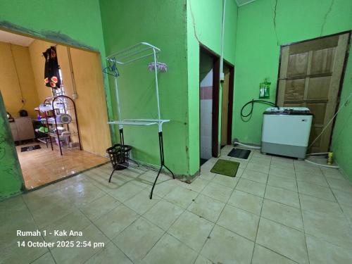 a room with a shower and a green wall at Rumah Kak Ana in Pasir Puteh
