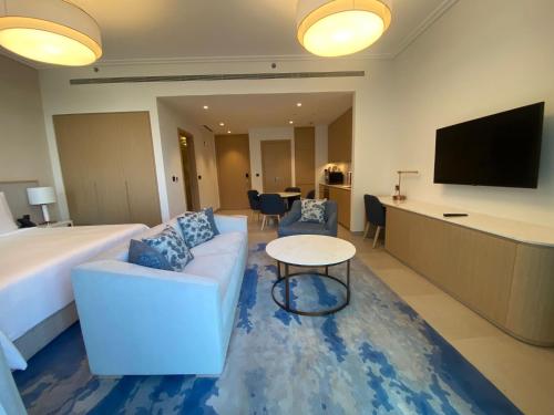 a hotel room with a bed and a couch and a table at Address Residence Marassi Vista-studio in Amwaj Island