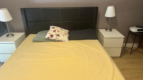 a bed with a pillow on it with two night stands at Berry in Setúbal