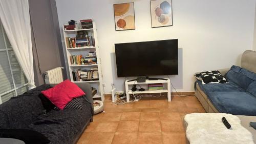 a living room with a couch and a flat screen tv at Berry in Setúbal