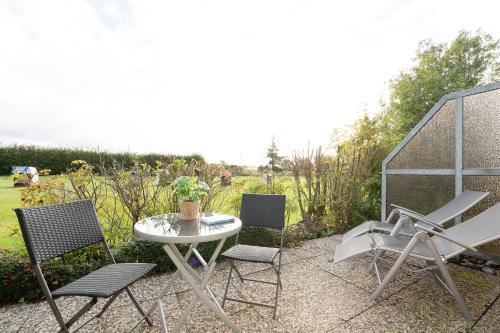 a patio with a table and chairs with a view of a field at Happy Place in Bojendorf