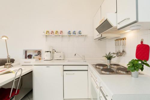 a white kitchen with white cabinets and a stove at Happy Place in Bojendorf
