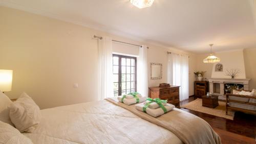 a bedroom with a bed with two towels on it at Casa da Joana, Quinta Carmo - Alcobaça/Nazaré in Alcobaça