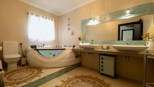 a bathroom with two sinks and a large mirror at Casa da Joana, Quinta Carmo - Alcobaça/Nazaré in Alcobaça