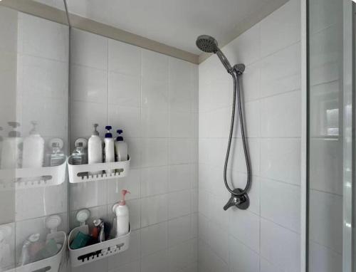 a shower in a white tiled bathroom with a shower head at Granadilla st queen bed for couple 独立附属公寓5 in Brisbane