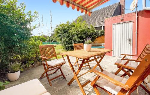 une table et des chaises en bois sur une terrasse dans l'établissement Stunning Home In Friedrichskoog With Wifi, à Friedrichskoog-Spitz