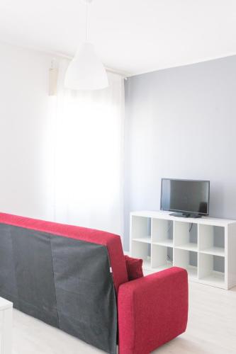 a living room with a red couch and a tv at B&B Via Nazionale in Milazzo