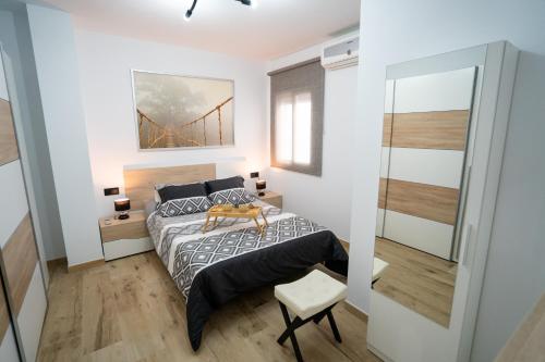 ein Schlafzimmer mit einem Bett und einem Spiegel in der Unterkunft Encanto en Iznájar con terraza y vistas a la montaña in Iznájar