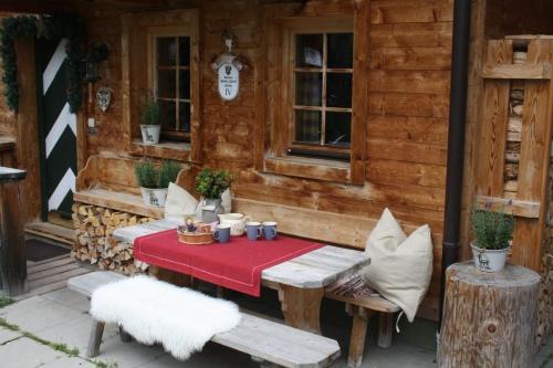 ホーホフューゲンにあるKaiser-Franz-Josef Hüttenの赤いテーブルクロスがかかったテーブルのある木造の小屋