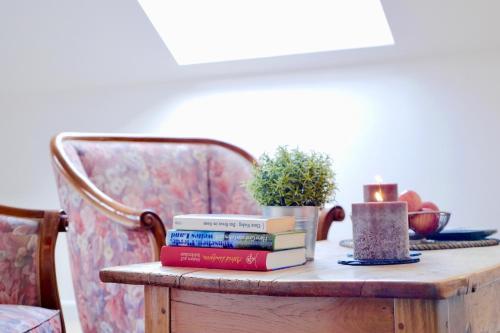 a pile of books on a table with a chair at Ferien- Monteurwohnung in Zülpich in Zülpich