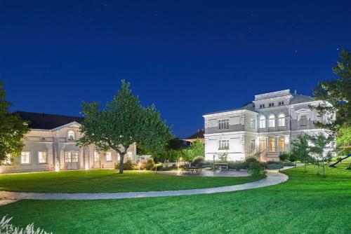 a large white house with a green lawn at night at Villa Romana Apartments with Terrace & Private Entrance in Baden