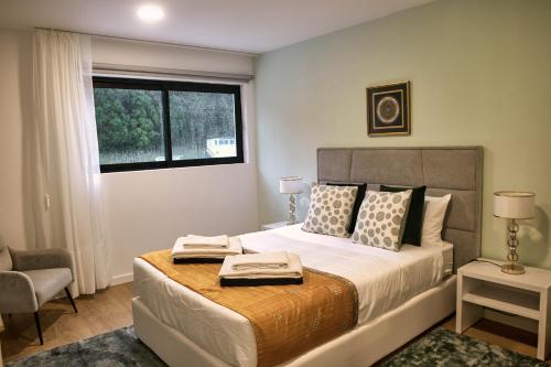 a bedroom with a bed with two towels on it at InSide Furnas in Furnas