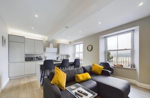 a living room with a couch and a kitchen at Aurora House 2B Warrenpoint in Newry