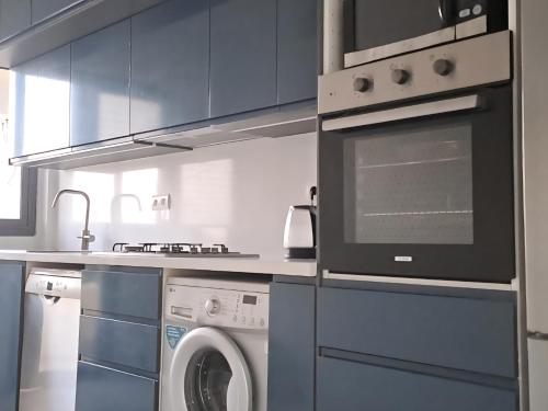 a kitchen with a stove and a washing machine at iris appart vue dégagée, bon emplacement in Sale