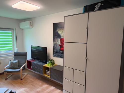 ein Wohnzimmer mit einem großen weißen Schrank und einem Fernseher in der Unterkunft Pension Hettstedt in Hettstedt