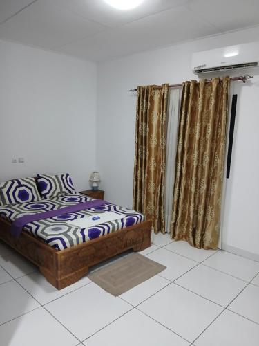 a bedroom with a bed and a window with curtains at Résidence Meublée Yaya Azur in Azuretti