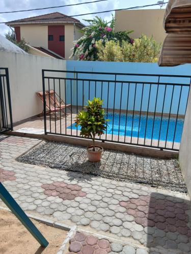 a fence with a potted plant in front of a pool at Résidence Meublée Yaya Azur in Azuretti
