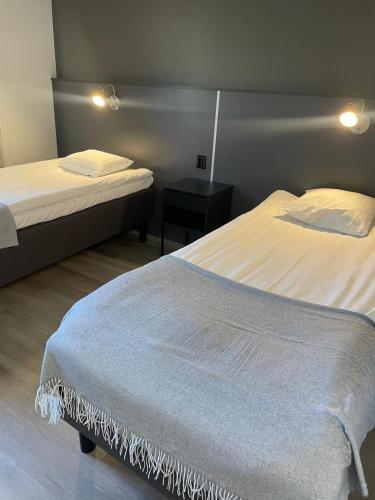 a bedroom with two beds and a night stand at Hotelli Puustelli Nivala in Nivala