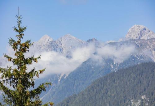 a view of a mountain range with clouds in the foreground at Chalet Hauserberg in Gumpenberg