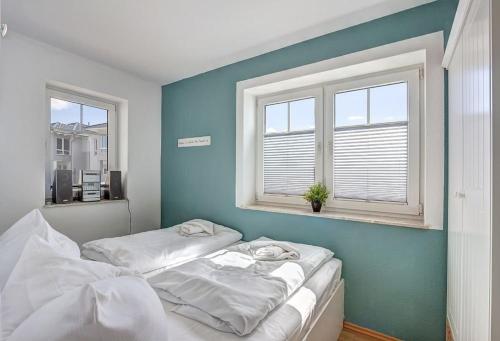 Dos camas en una habitación con dos ventanas. en Fewo Bruno, en Ahlbeck