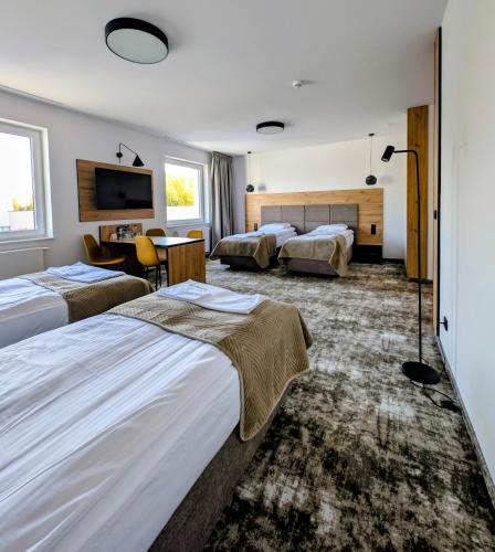 a hotel room with two beds and a tv at Hotel Eden in Rzgów