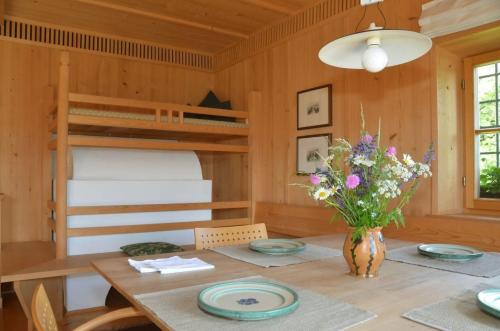 a dining room with a table and bunk beds at Kohlstatt Hütte in Verano
